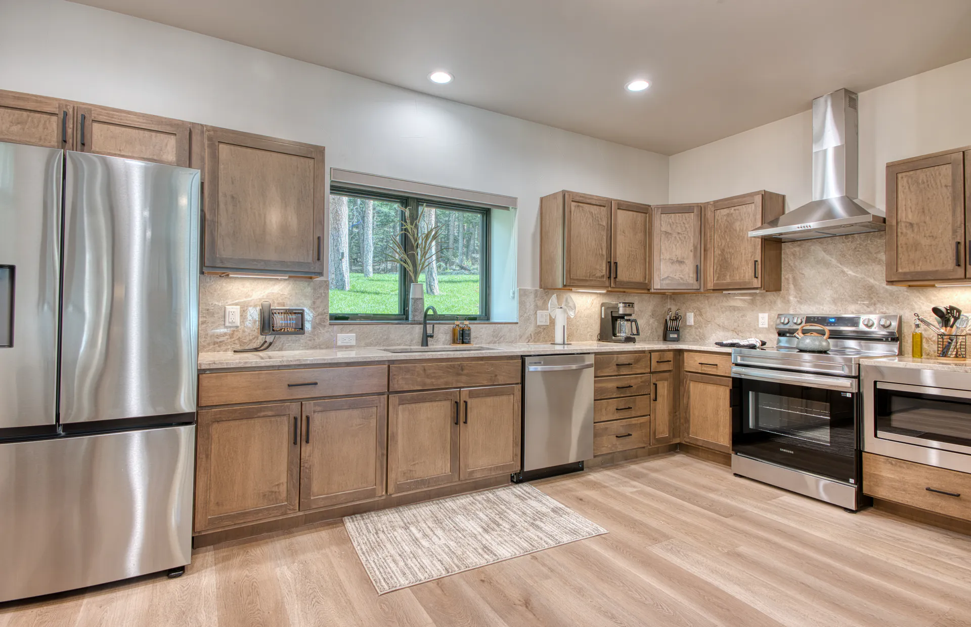 DreamView Hillside full kitchen with stainless appliances and a wooded outlook
