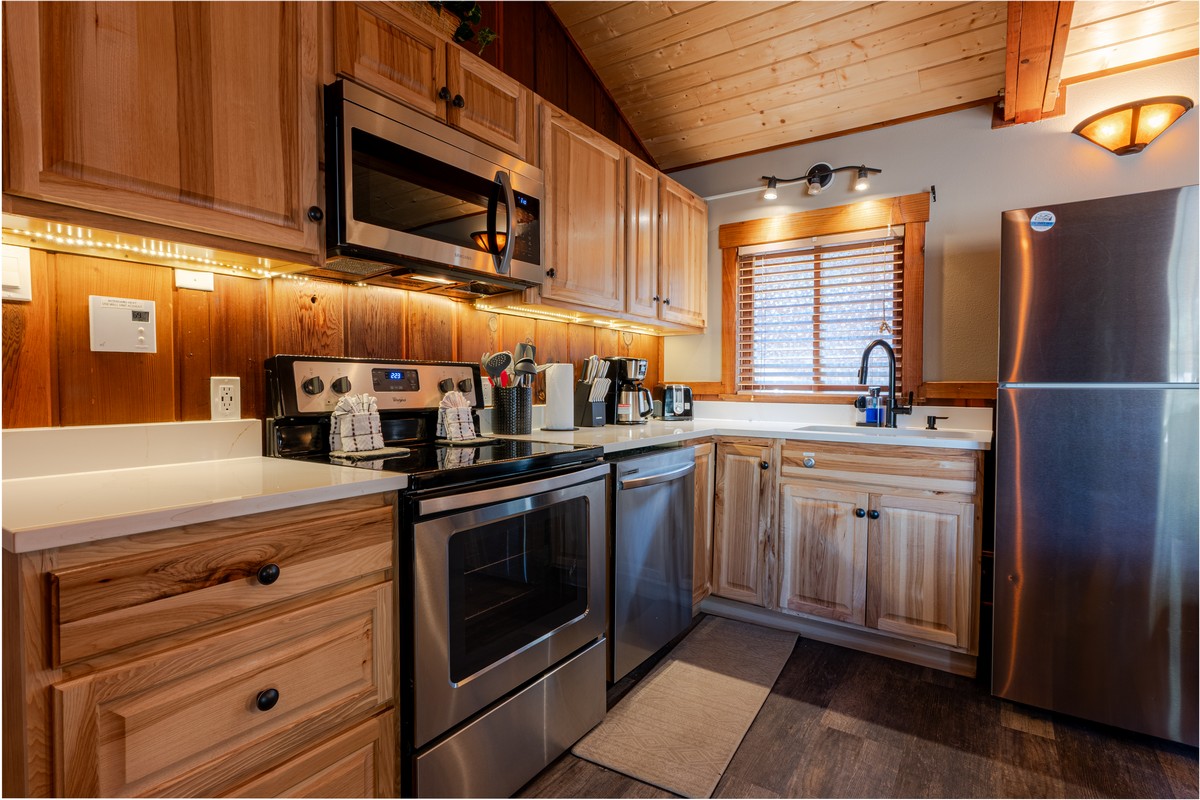 Fully-equipped kitchen in Estes Park condo with stainless steel appliances and quartz countertops.