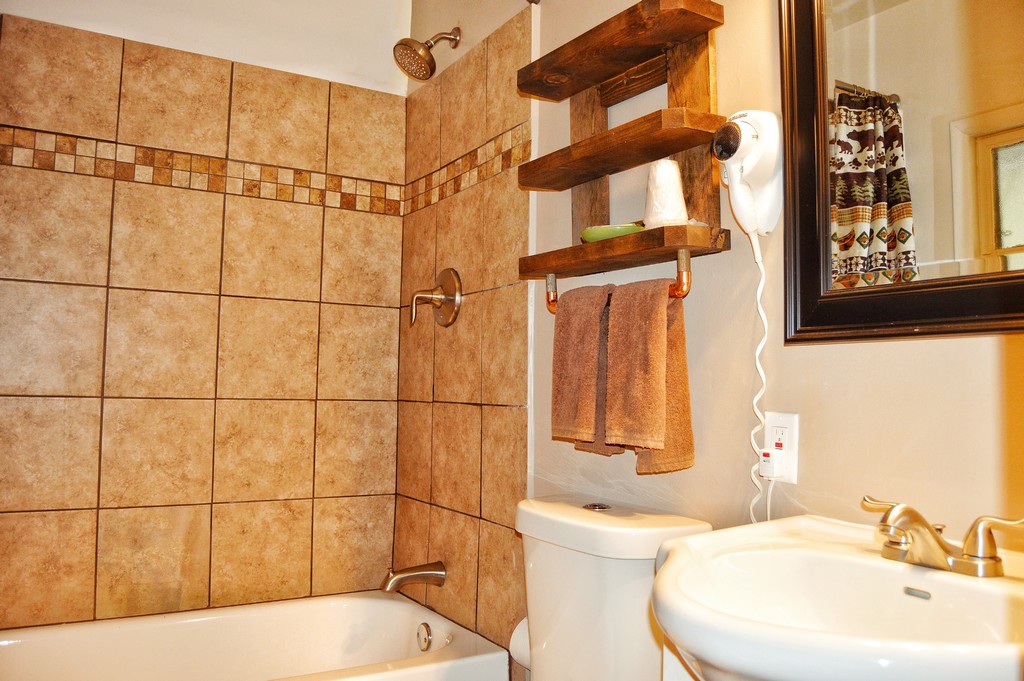 A bathroom with a bathtub, toilet, sink, and mirror